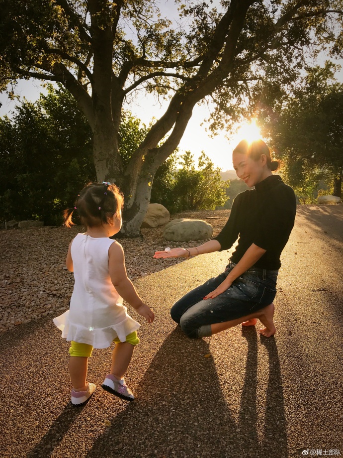 章子怡与女儿捡石子玩 夕阳下露会心微笑